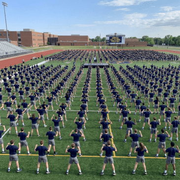 Students performing synchronized exercises on a school football field